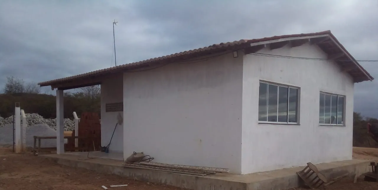 Edificação de alvenaria com telhado cerâmico e varanda, construída como sede administrativa da obra.